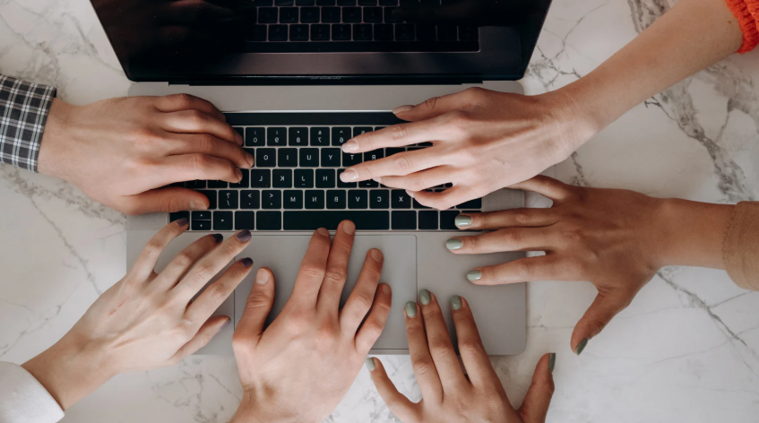 Peoples hands on laptop representing data expertise