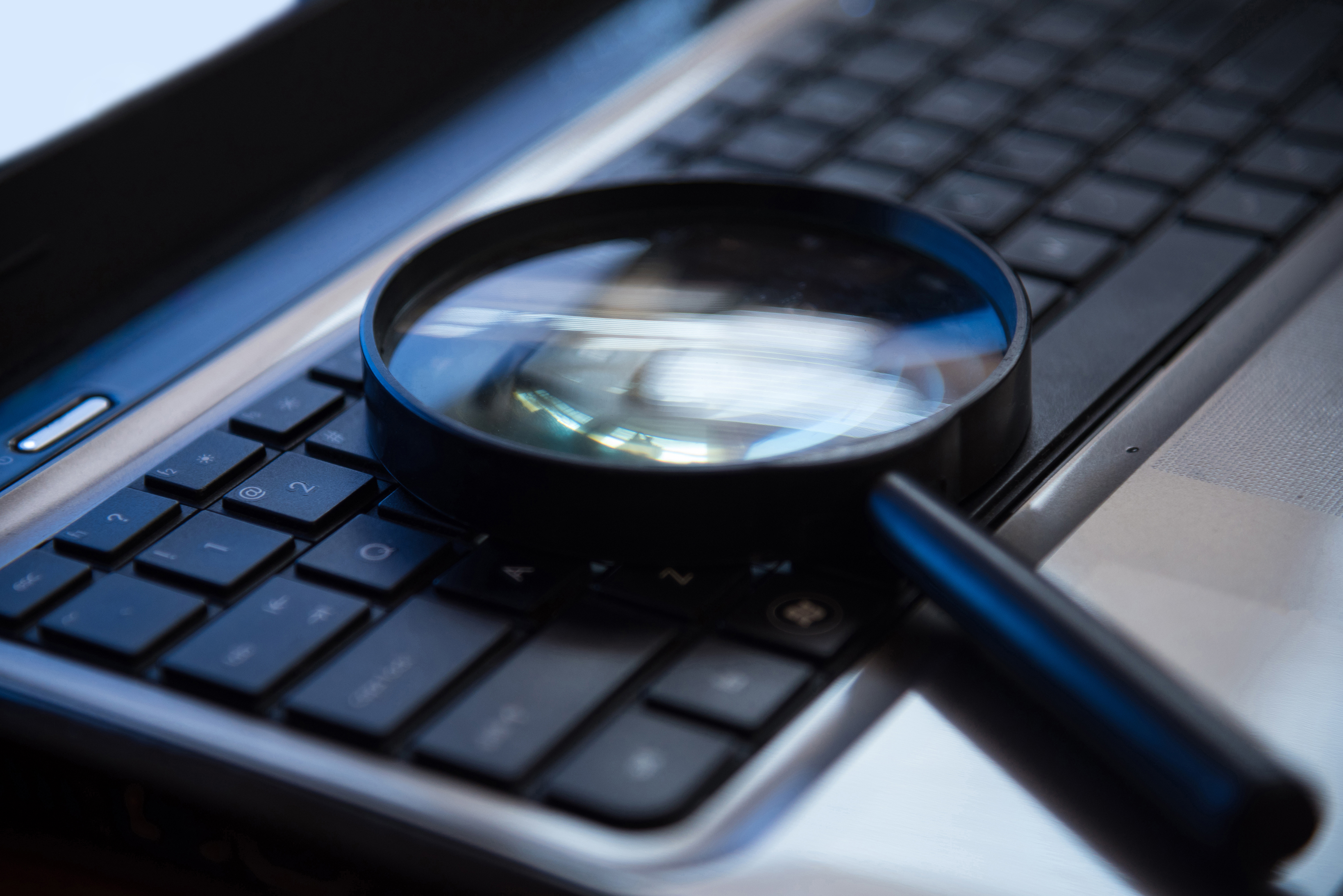 Magnifying glass sitting on computer keyboard