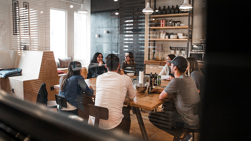 Colleagues conversing around a shared working space