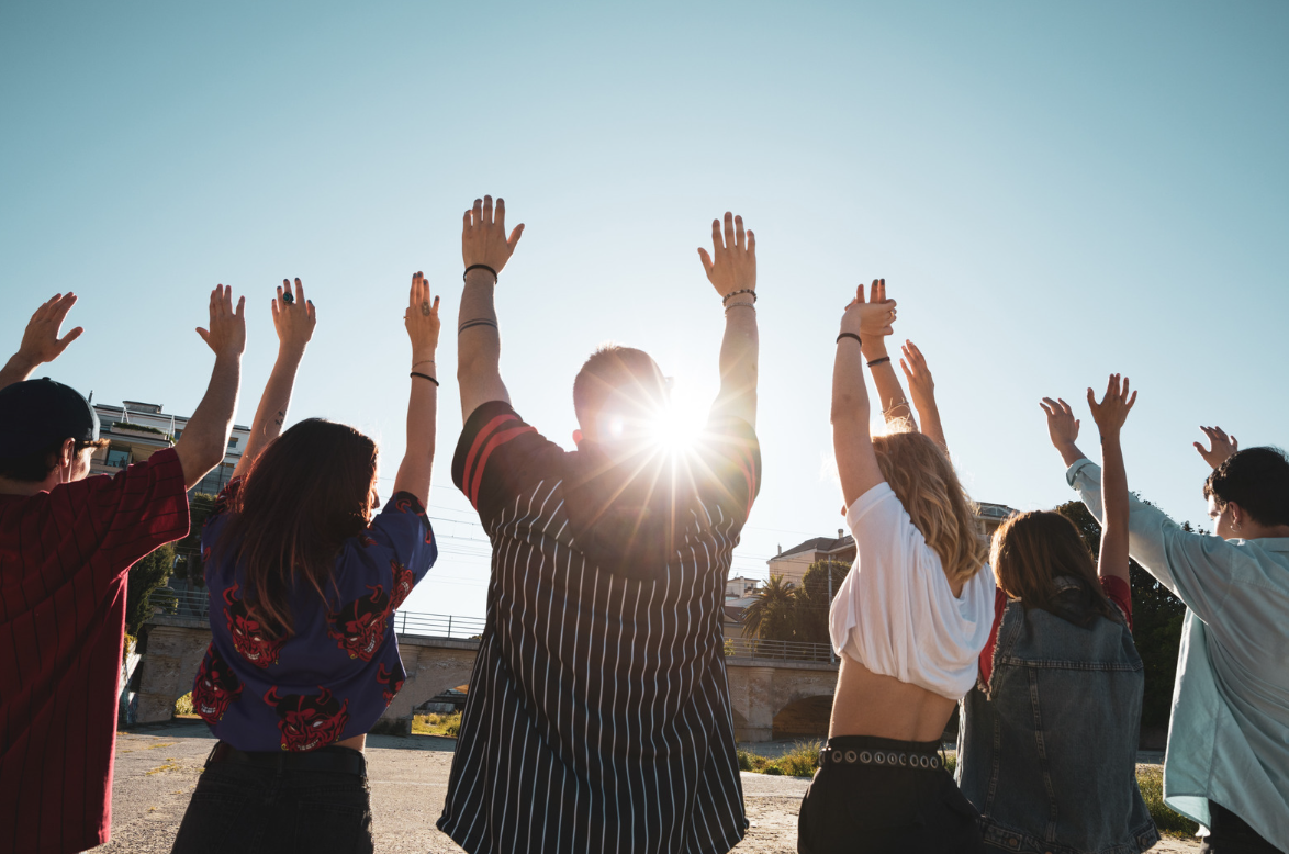 Group of Gen Z with their hands in the air